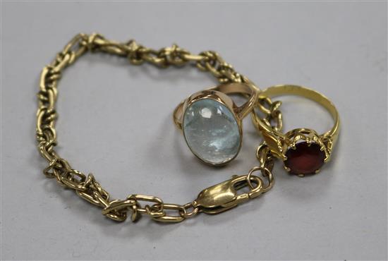 A gold curblink bracelet and two gem set rings.
